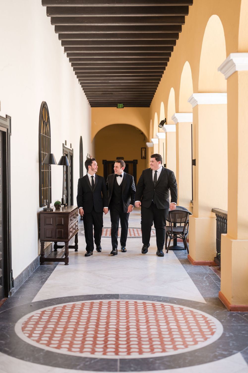 Groom walking through historic hallway at Hotel El Convento in Old San Juan