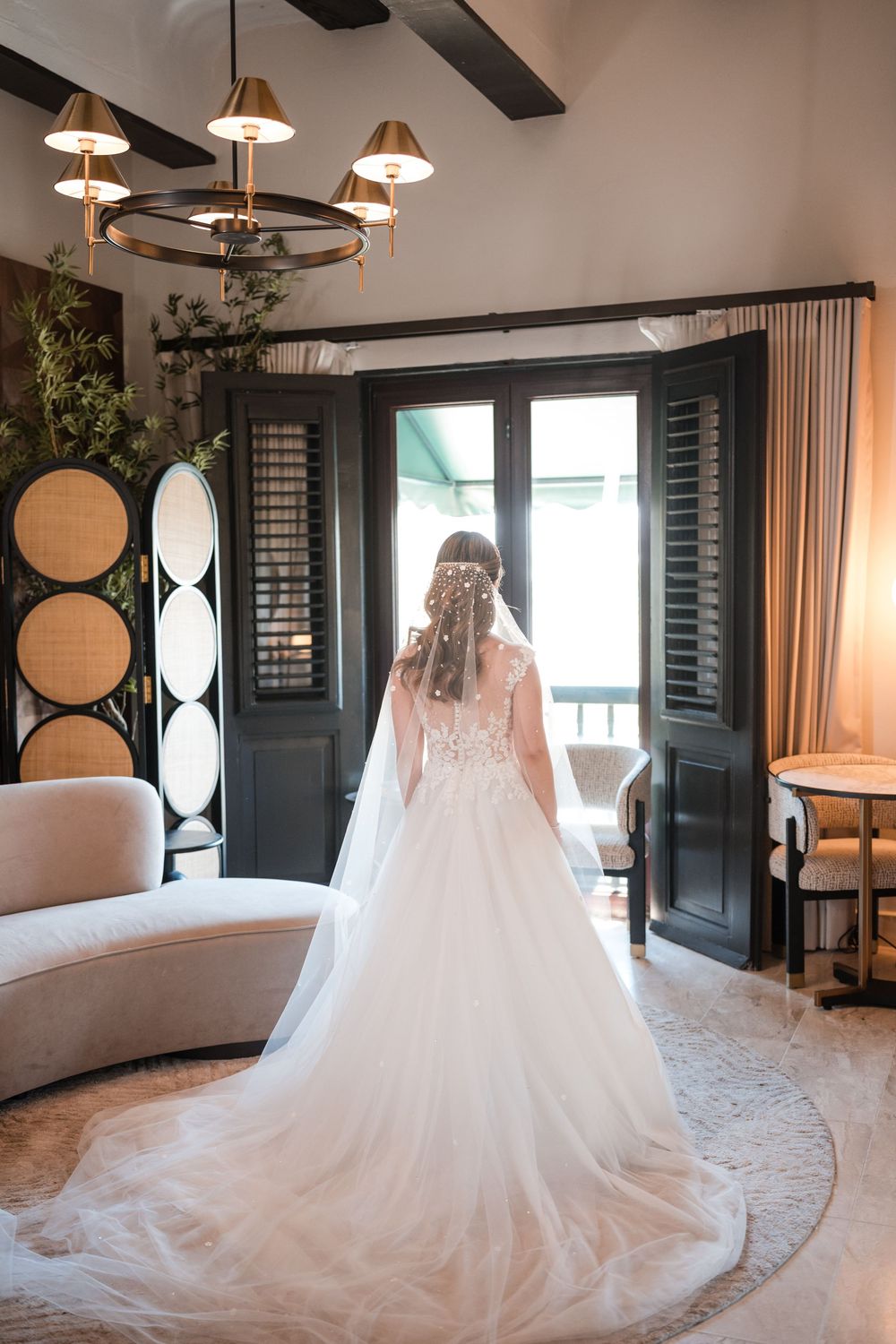 Bride standing by balcony doors in bridal suite at Hotel El Convento Old San Juan