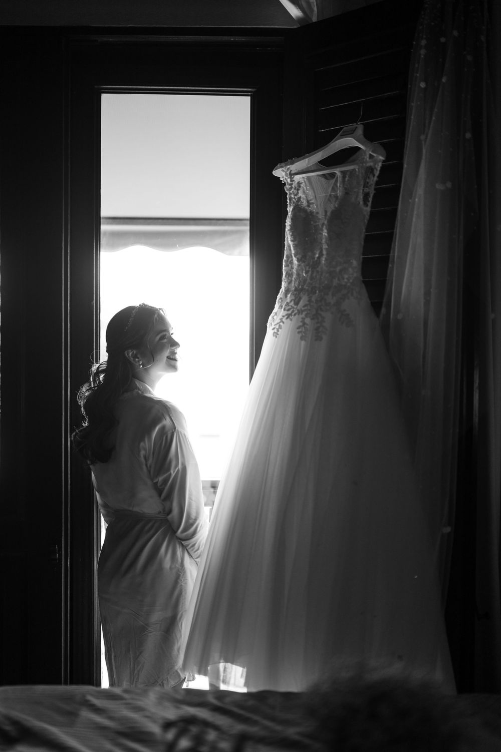 Bride silhouette next to wedding dress hanging by window at Hotel El Convento