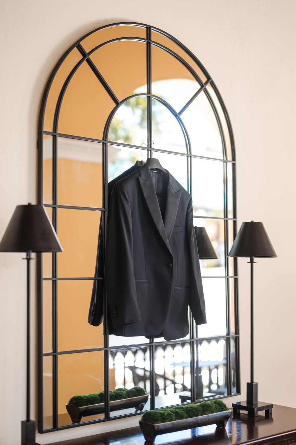 Groom suit hanging by arched window at Hotel El Convento wedding