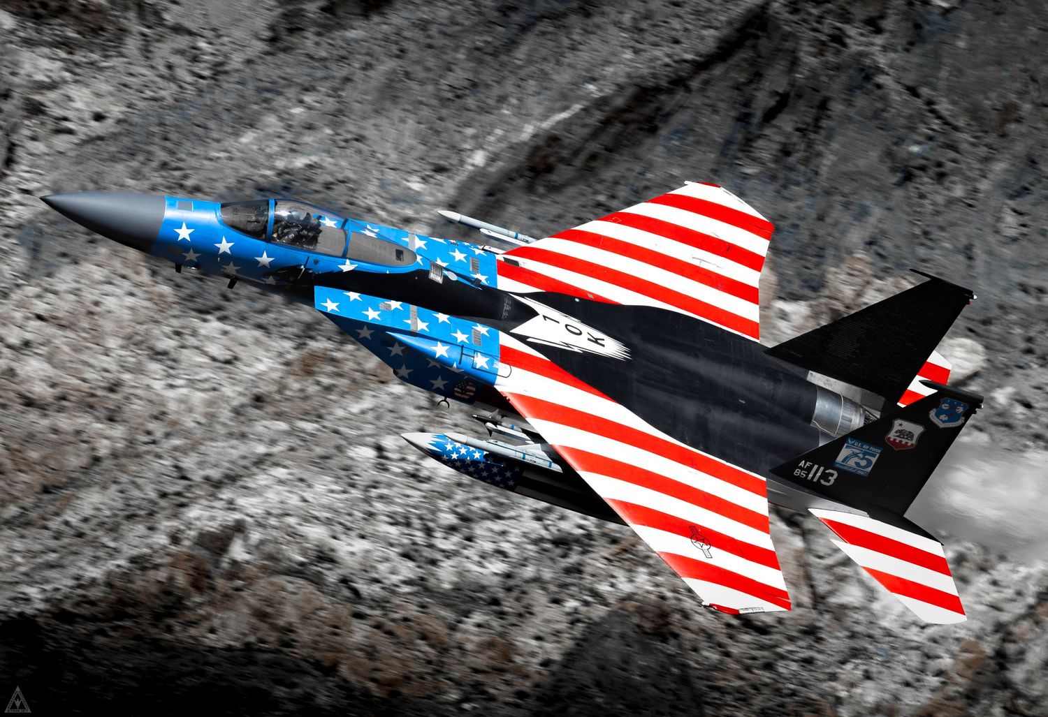 An American Flag painted F-15C Flies through a desert canyon