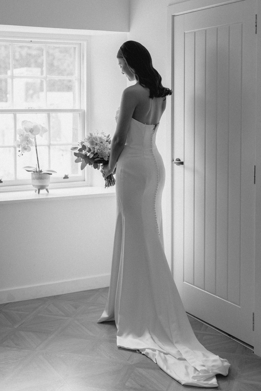 A bride in a white wedding gown stands in a bright room with windows, shown in a series of elegant poses.