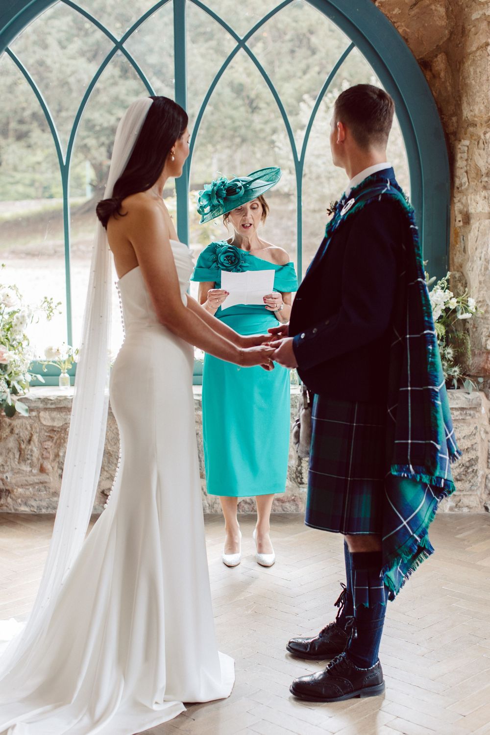 A sequence of wedding photos showing a ring bearer in a kilt presenting a turquoise gift box to the bride.