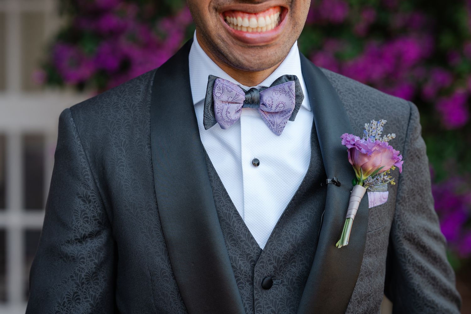 Close-up sequence of purple and pink floral boutonnieres pinned to dark textured suit lapels.