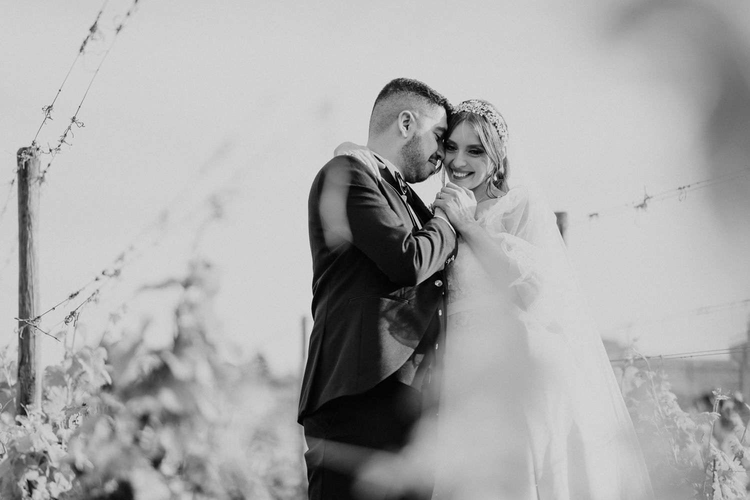 Black and white wedding photography series showing intimate romantic moments between newlyweds in an outdoor setting.