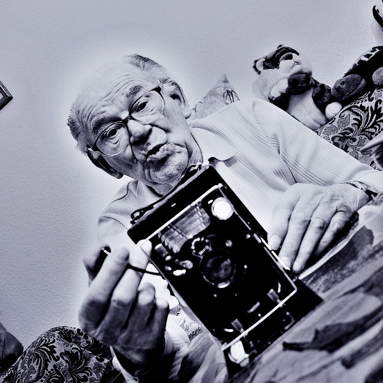A series of black and white photographs showing hands holding vintage photographs and cameras in a nostalgic style.