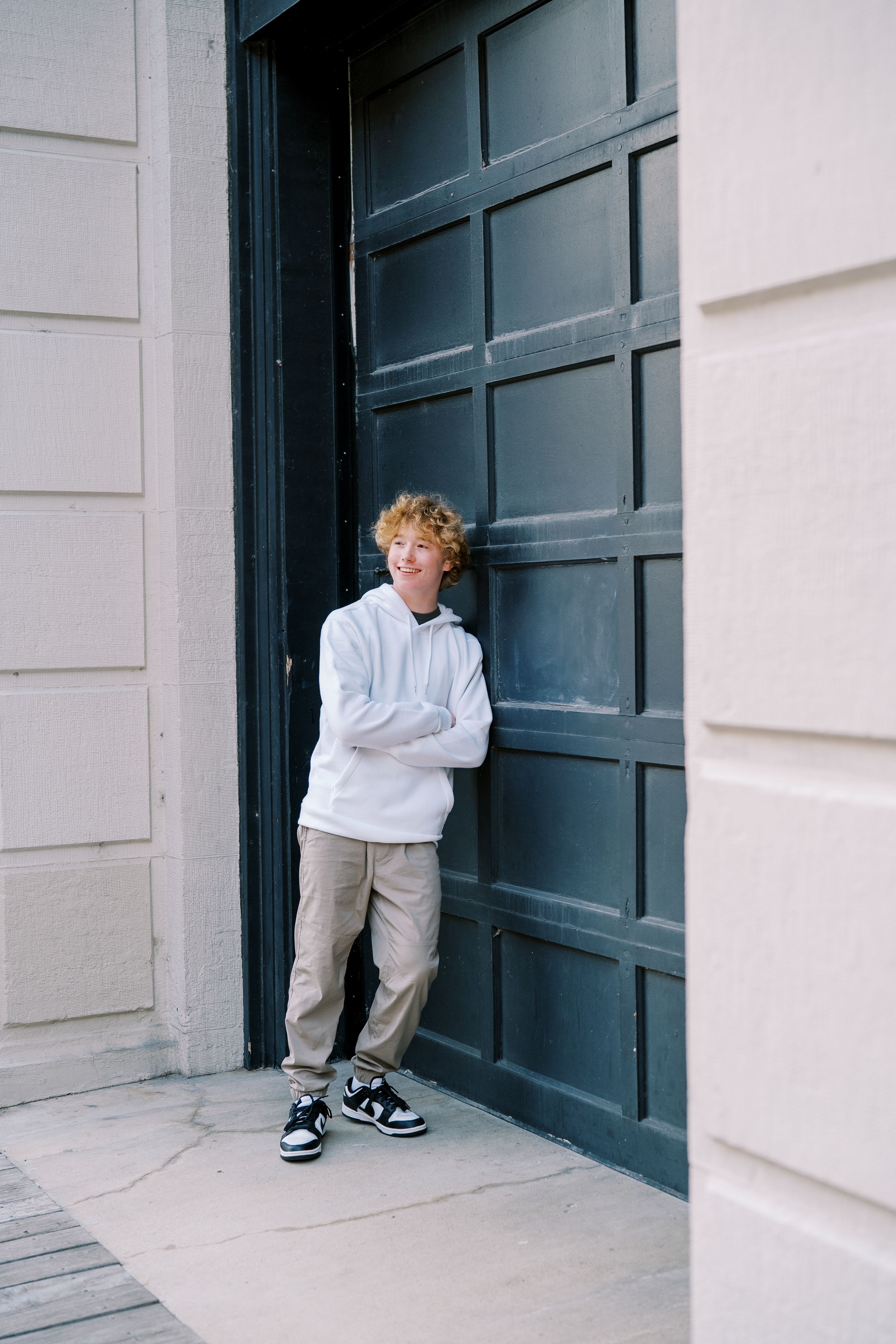 Artistic portrait series against dark door and white wall showing different poses.