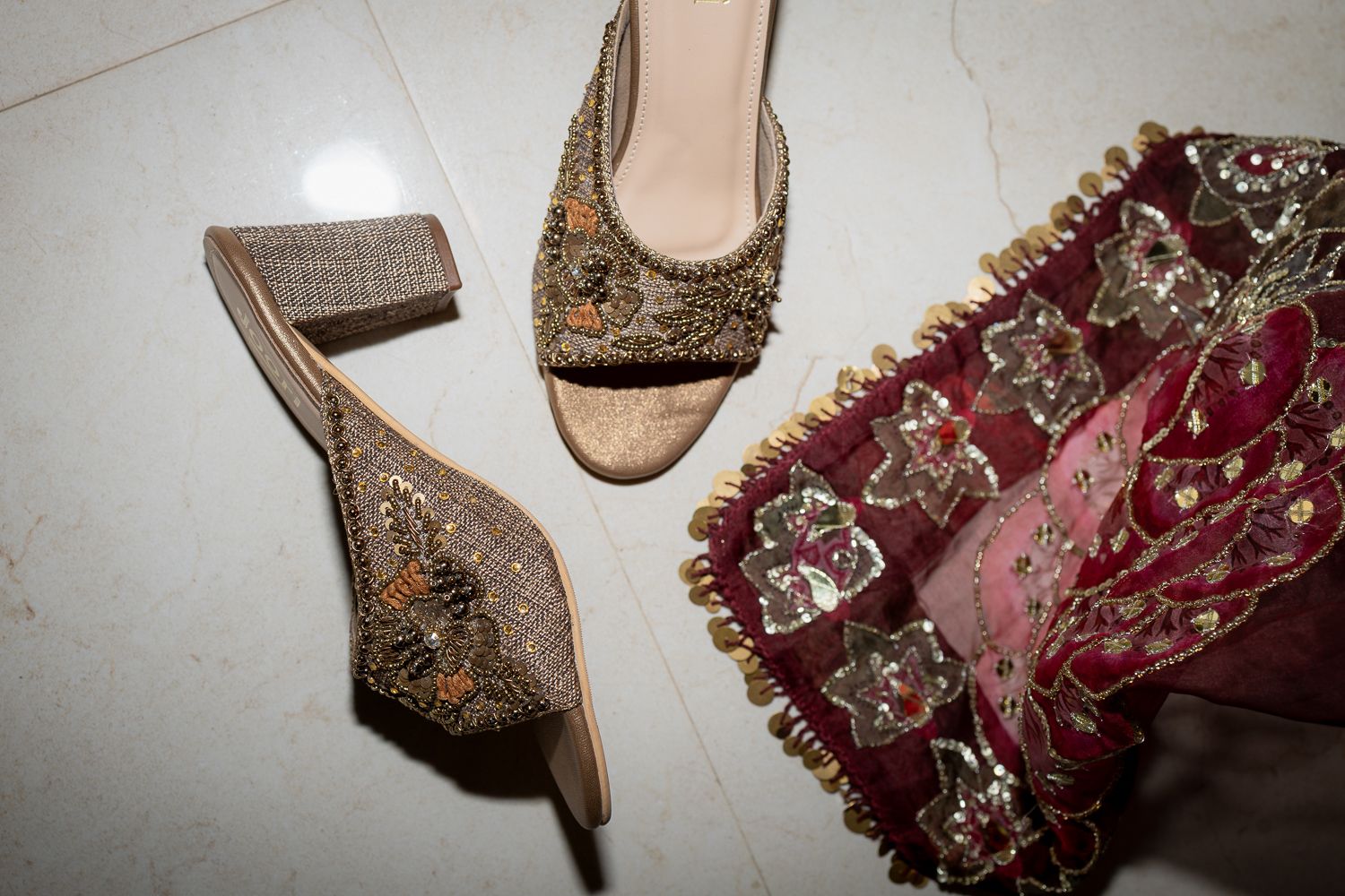 Elegant beaded and embellished evening shoes and clutch bags in burgundy and gold tones displayed together.