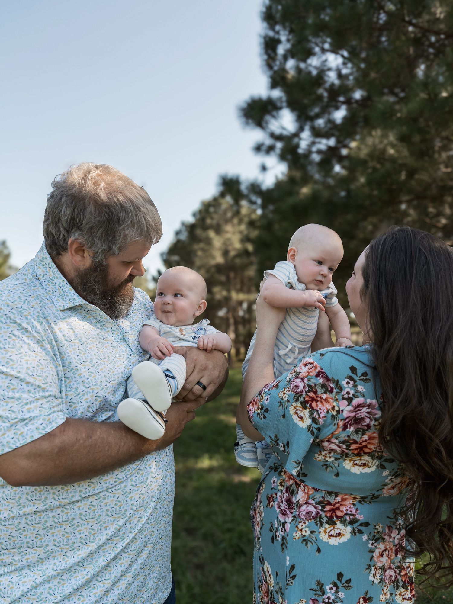 A series of tender outdoor family moments showing parents interacting with their baby in a natural setting.