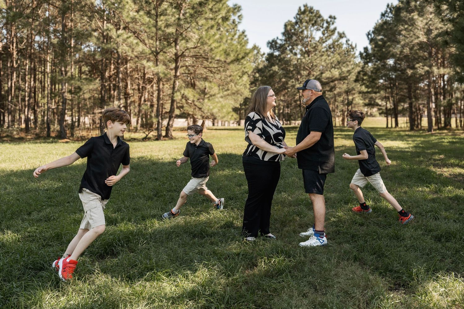 A sequence of playful outdoor photos showing people falling down in the grass while having fun.