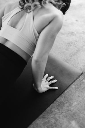 Black and white close-up sequence showing hands and arms performing yoga poses on a mat.