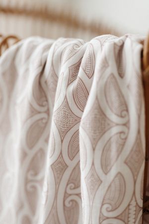 Close-up of cream colored fabric with elegant geometric pattern design.