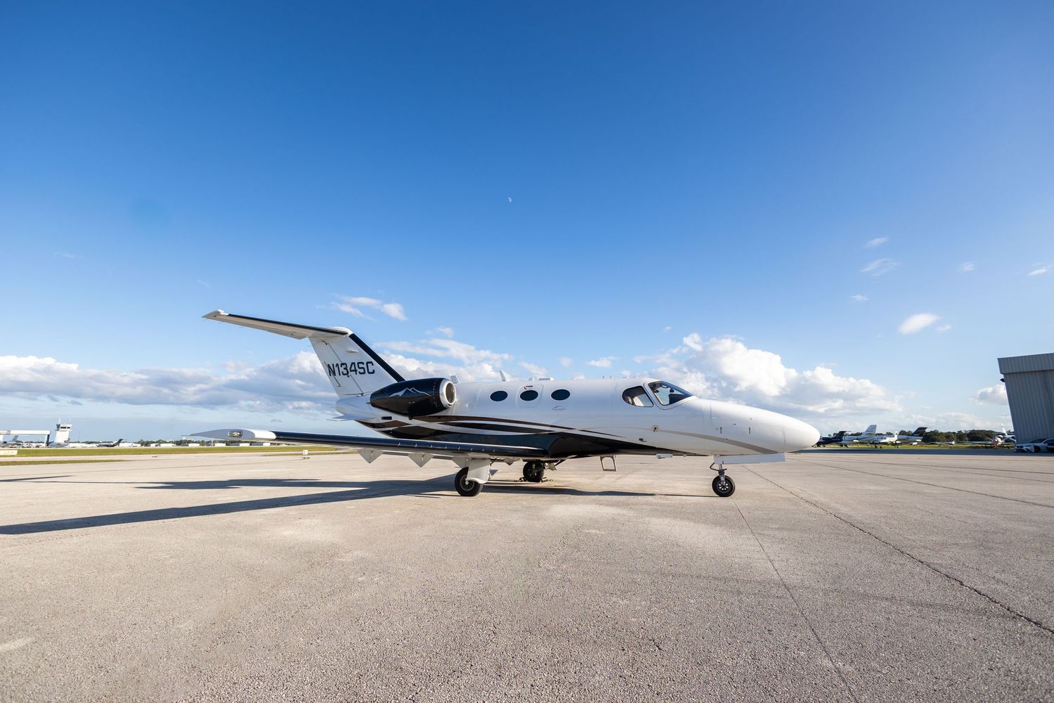 Private jet aircraft photography on the tarmac with white clouds and blue sky in the background. Sarasota Commercial Photographer