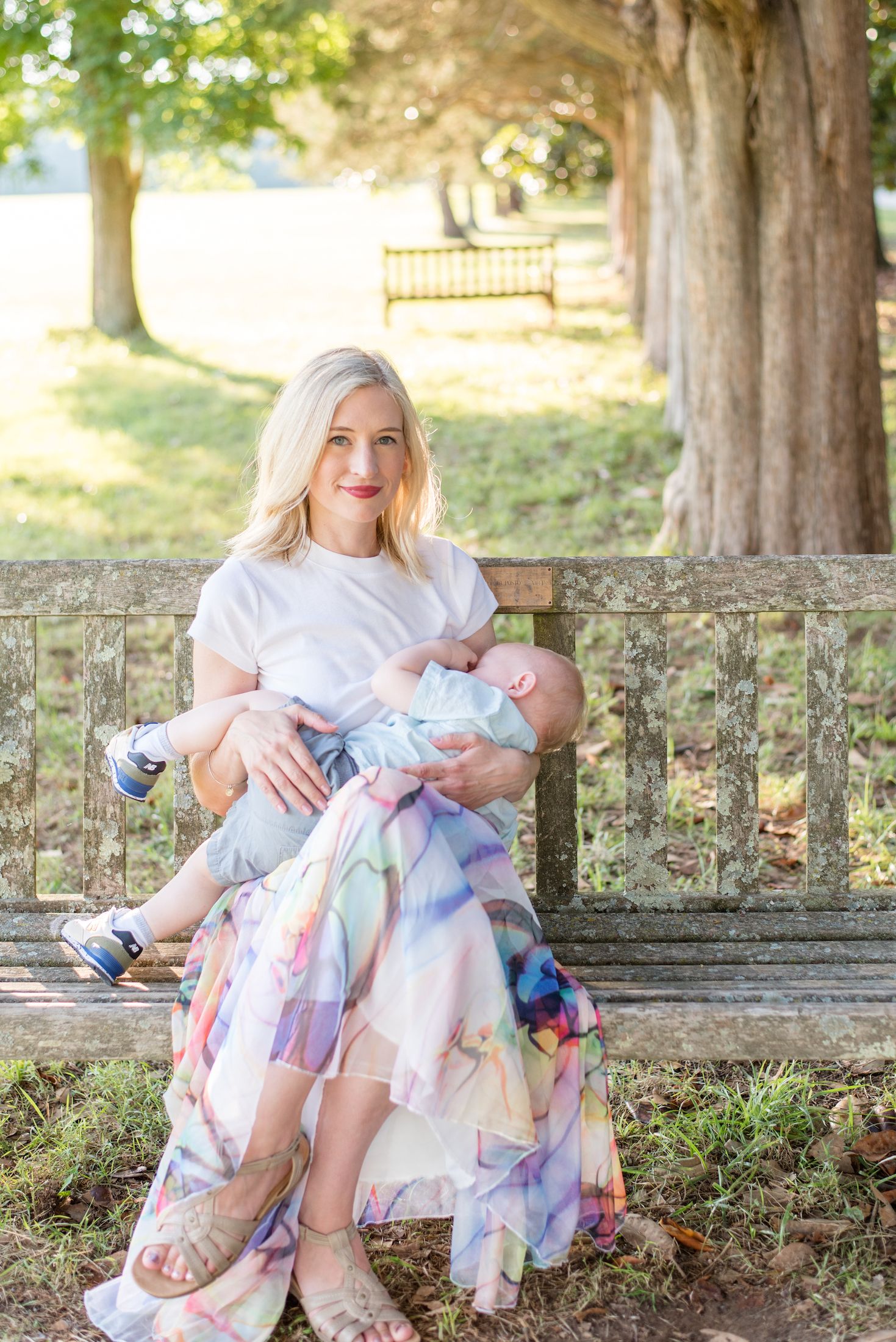 Intimate nursing portrait of a mom on a park bench at Gunston Hall Virginia during an outdoor family session with Sarah Thayer Photography