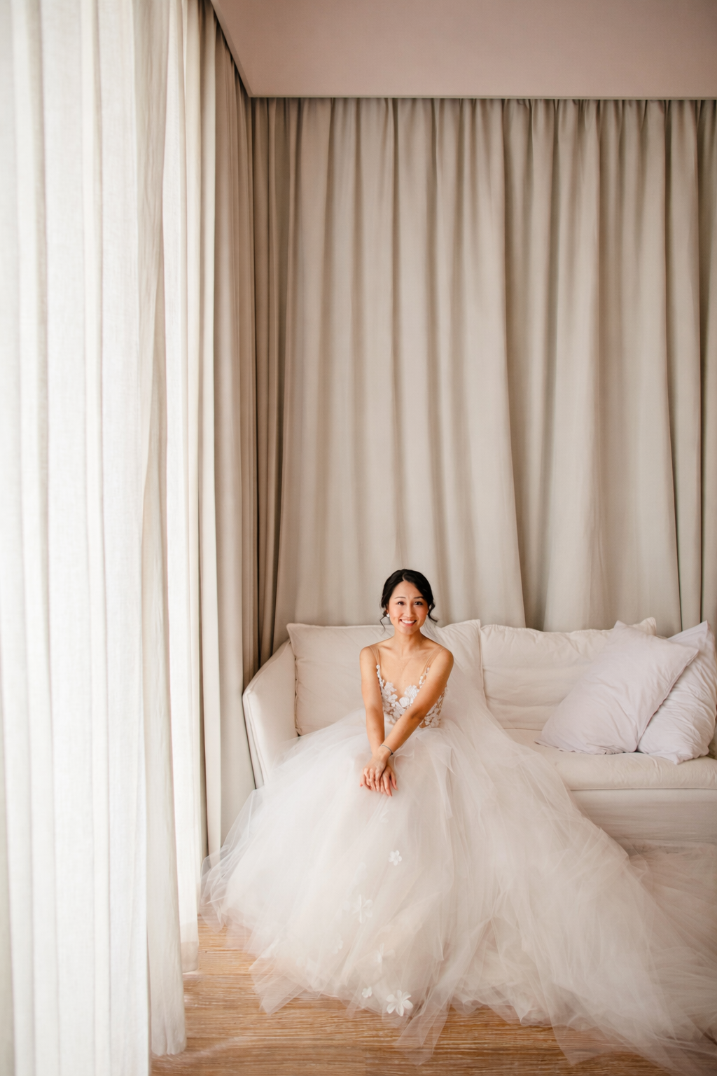 bride in elegant wedding dress sitting on sofa during getting ready at luxury villa Ban Suriya Koh Samui