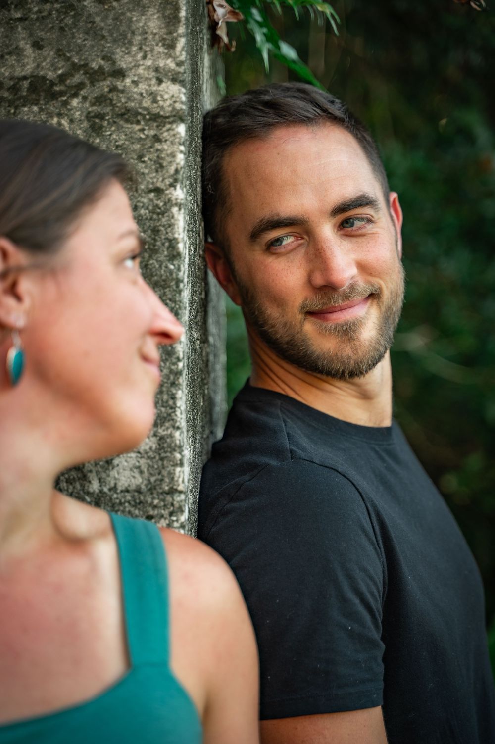 Close-up sequence showing a couple leaning against a stone pillar in an intimate pose.