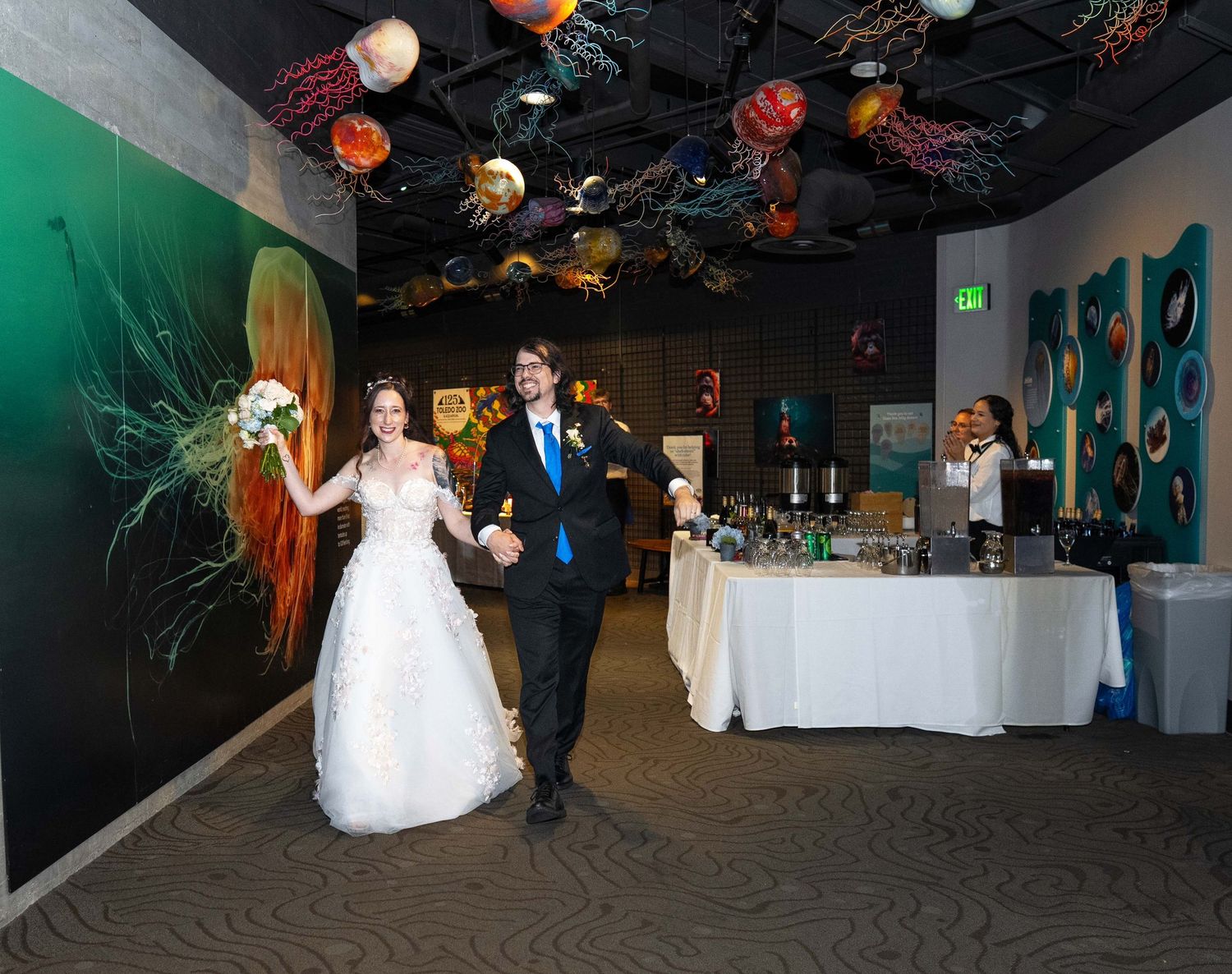Bride and groom walk hand-in-hand at wedding reception Toledo Zoo Wedding Venue