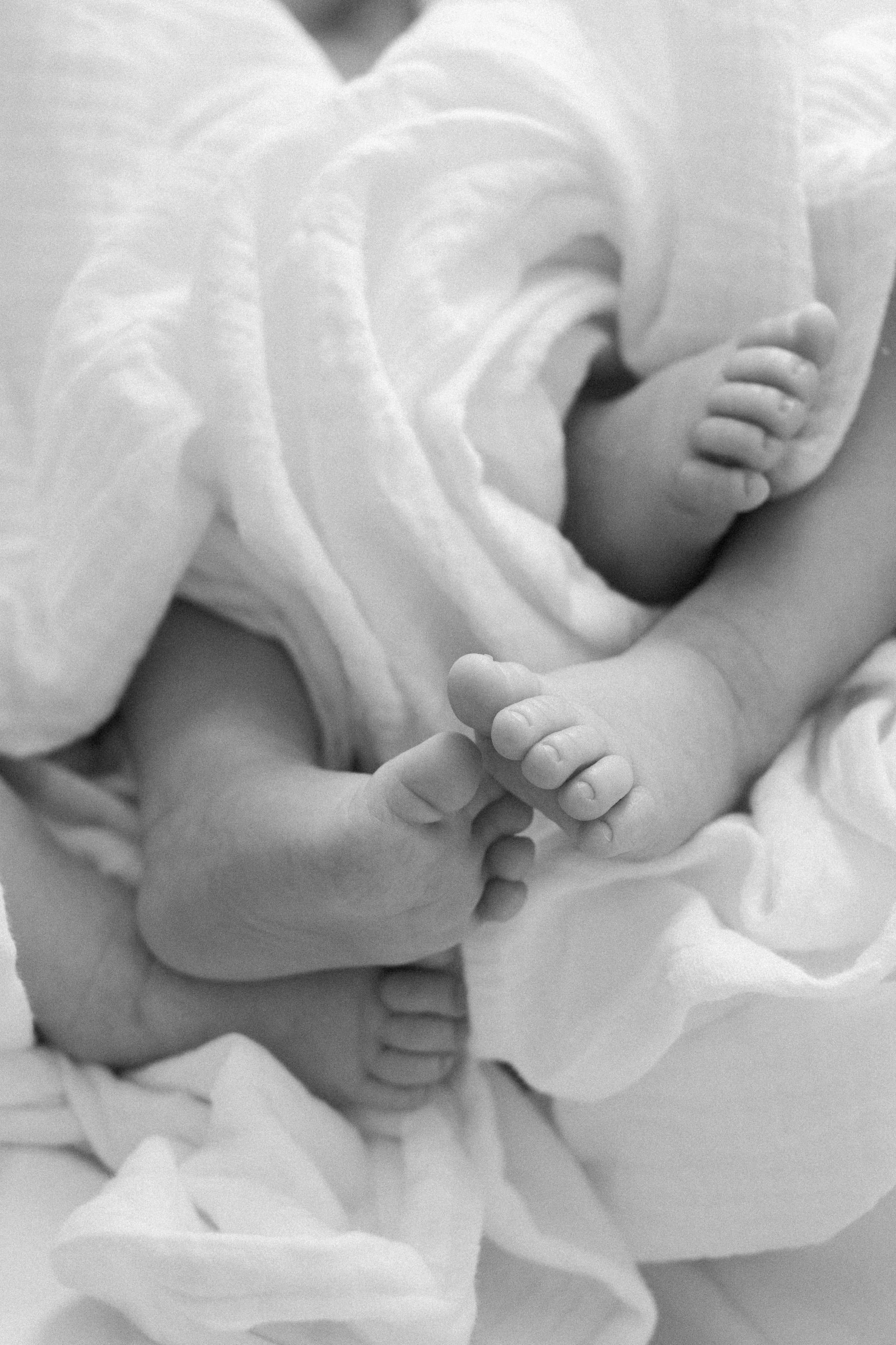 A black and white series of close-up photos showing delicate white fabric folds and gentle hand gestures.