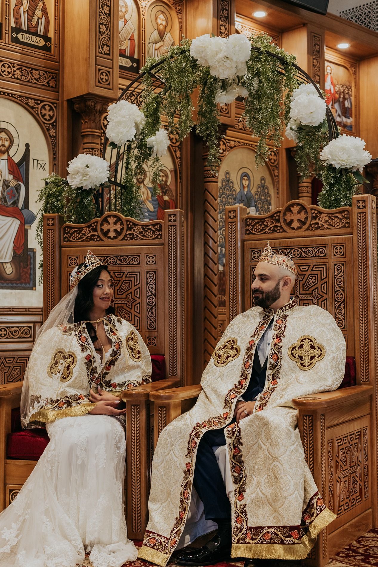 Ornate wooden church interior with religious icons and decorative carvings on the walls and panels.