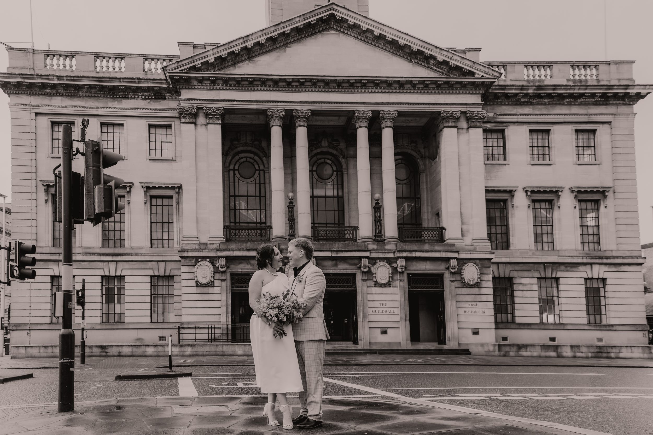 Historic black and white photographs show the exterior of a grand neoclassical government building with columns and ornate details.
