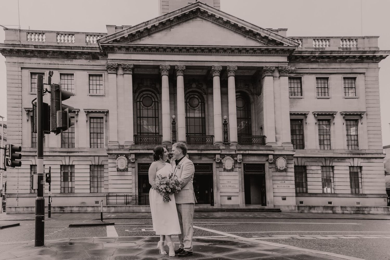 Historic black and white photographs show the exterior of a grand neoclassical government building with columns and ornate details.