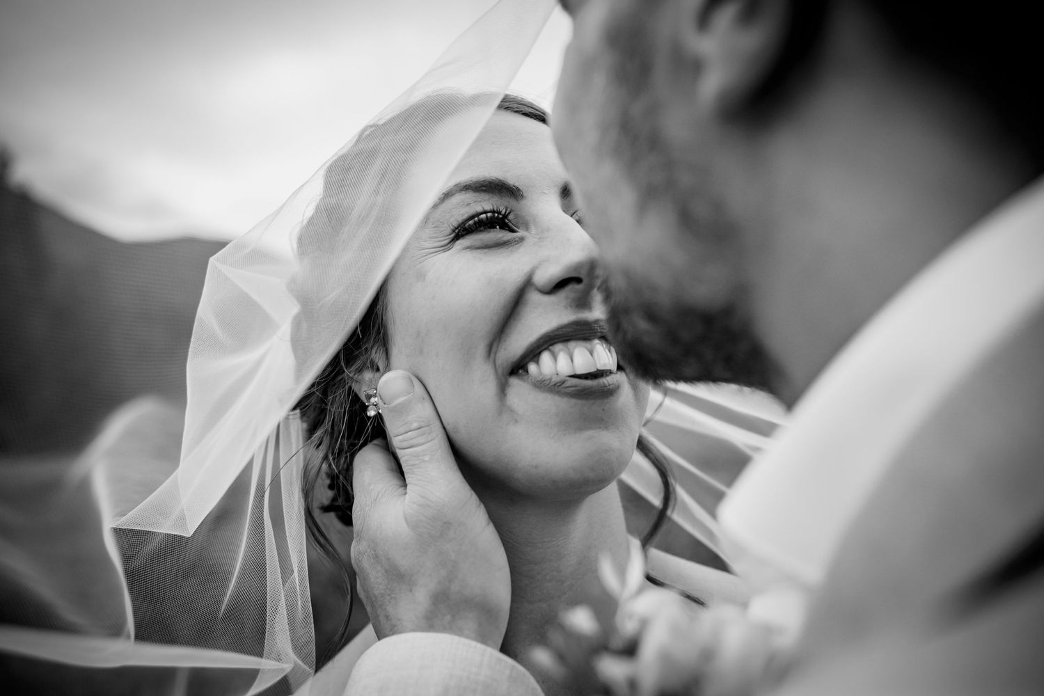 Black and white intimate moment between newlyweds sharing a joyful laugh during their wedding day.