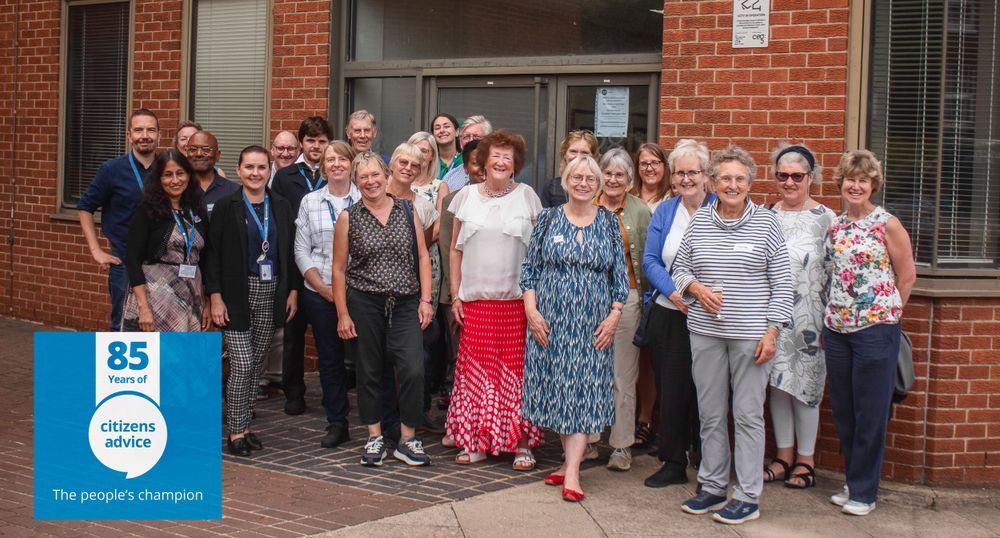 A group of people from Citizens Advice stand together smiling outside a brick building.
