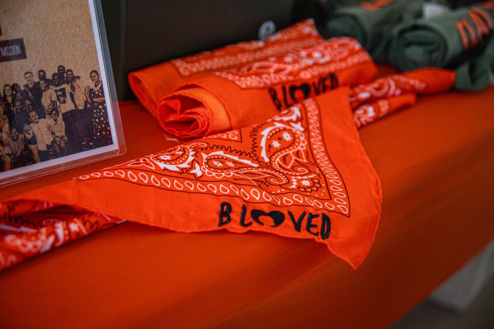 Orange bandanas with decorative patterns laid out on display surface.