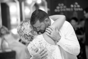 Black and white candid dance photo showing intimate embrace at wedding reception.