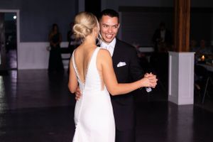 A couple shares their first dance in an elegant ballroom setting during their wedding reception.