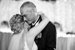 Intimate black and white portrait of couple sharing tender moment at reception.