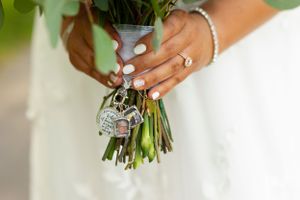 Close up of bride's hands holding bouquet showing engagement ring and bracelet details.