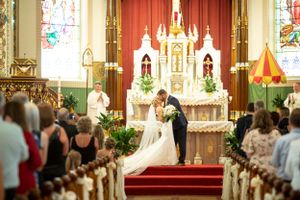 Traditional church wedding ceremony in ornate cathedral with stained glass windows.