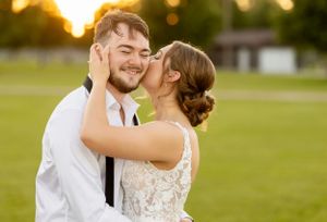 A joyful wedding moment captured during golden hour in an outdoor setting.