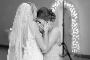 Emotional moment between two people in formal attire under twinkling lights.