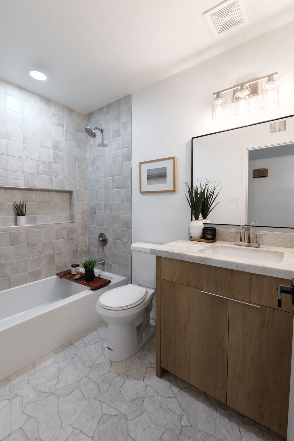 Modern bathroom with grey tile, floating vanity, and built-in bathtub niche. MLS Photographer, Phoenix Arizona