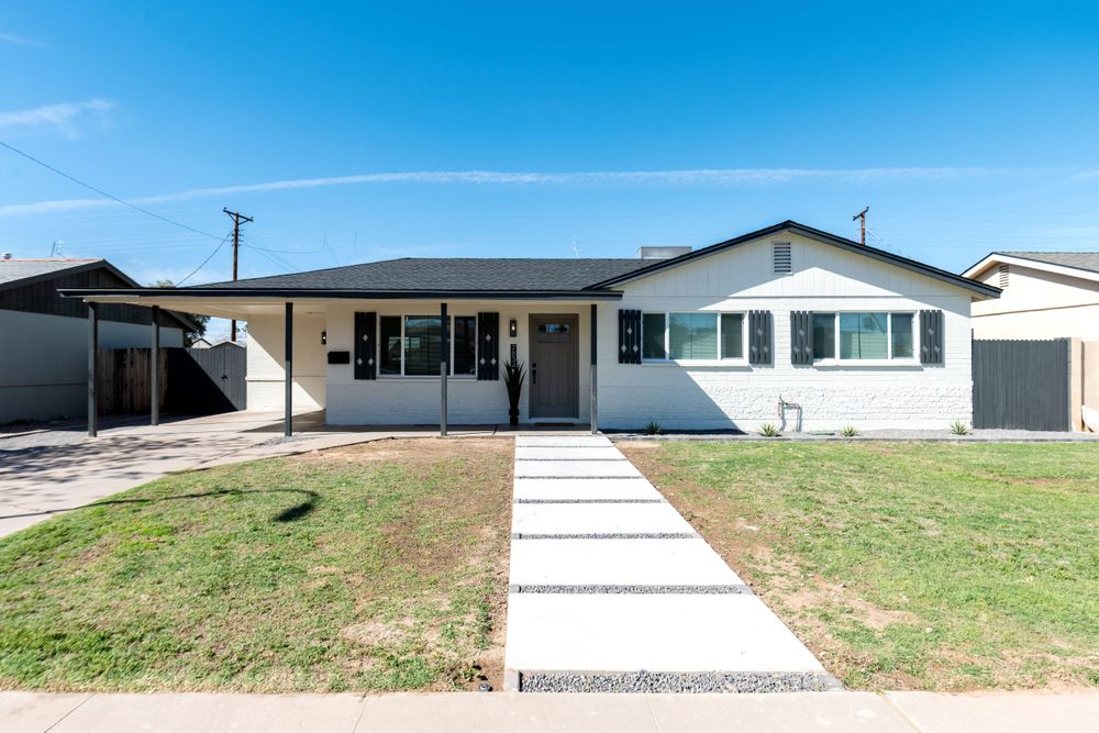Single-story ranch house exterior with concrete walkway and carport on a landscaped lawn. MLS Photographer, Phoenix Arizona