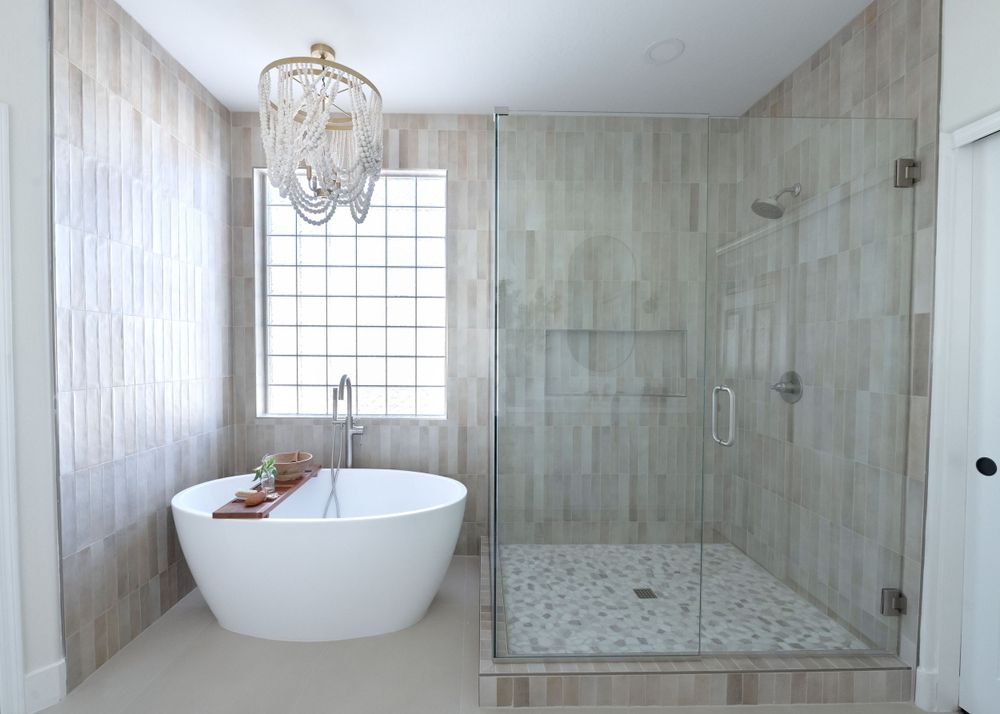 Contemporary bathroom featuring freestand soaking tub, glass shower, and chandelier lighting.  Phoenix Arizona Interior Desing Photographer