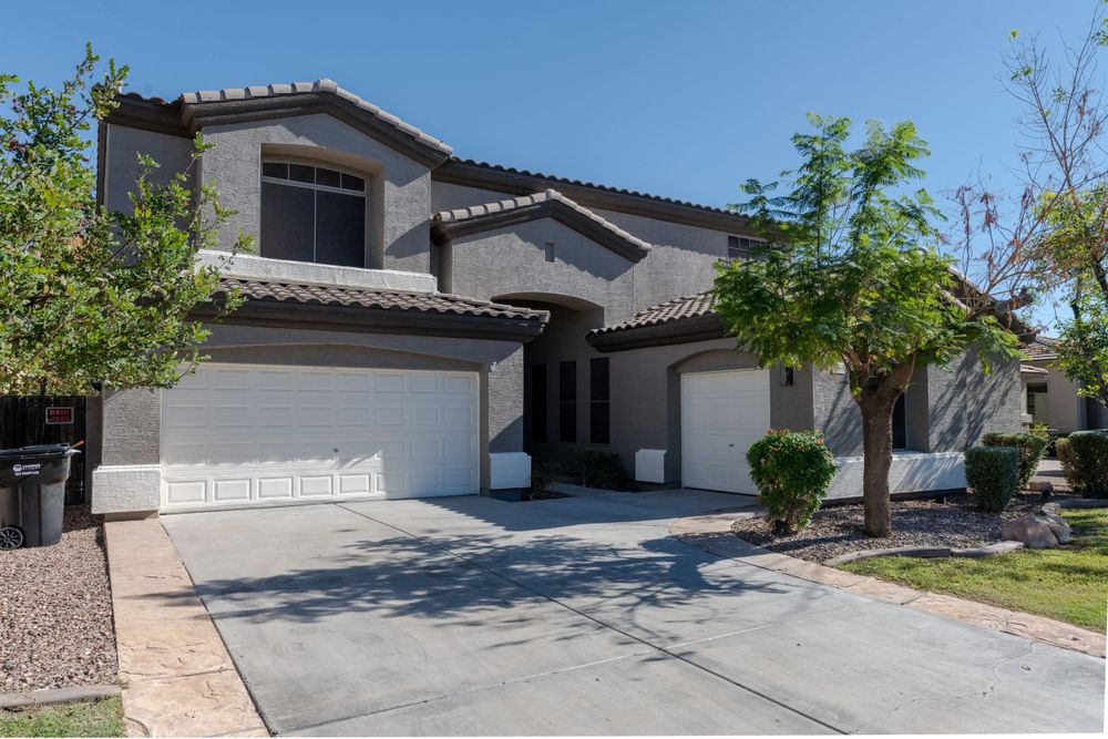 Large two-story stucco house tile roof, double garage and desert landscaping in suburban neighborhood. MLS Photographer, Phoenix Arizona