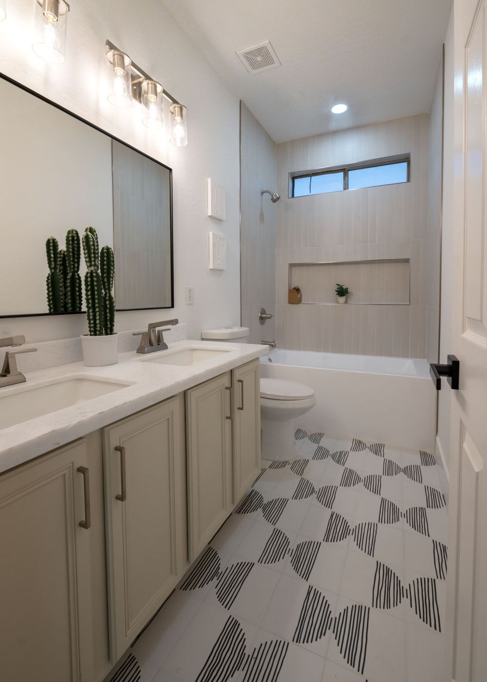 Contemporary bathroom with geometric floor tiles, double vanity, and modern fixtures with cactus decor. MLS Photographer, Phoenix Arizona