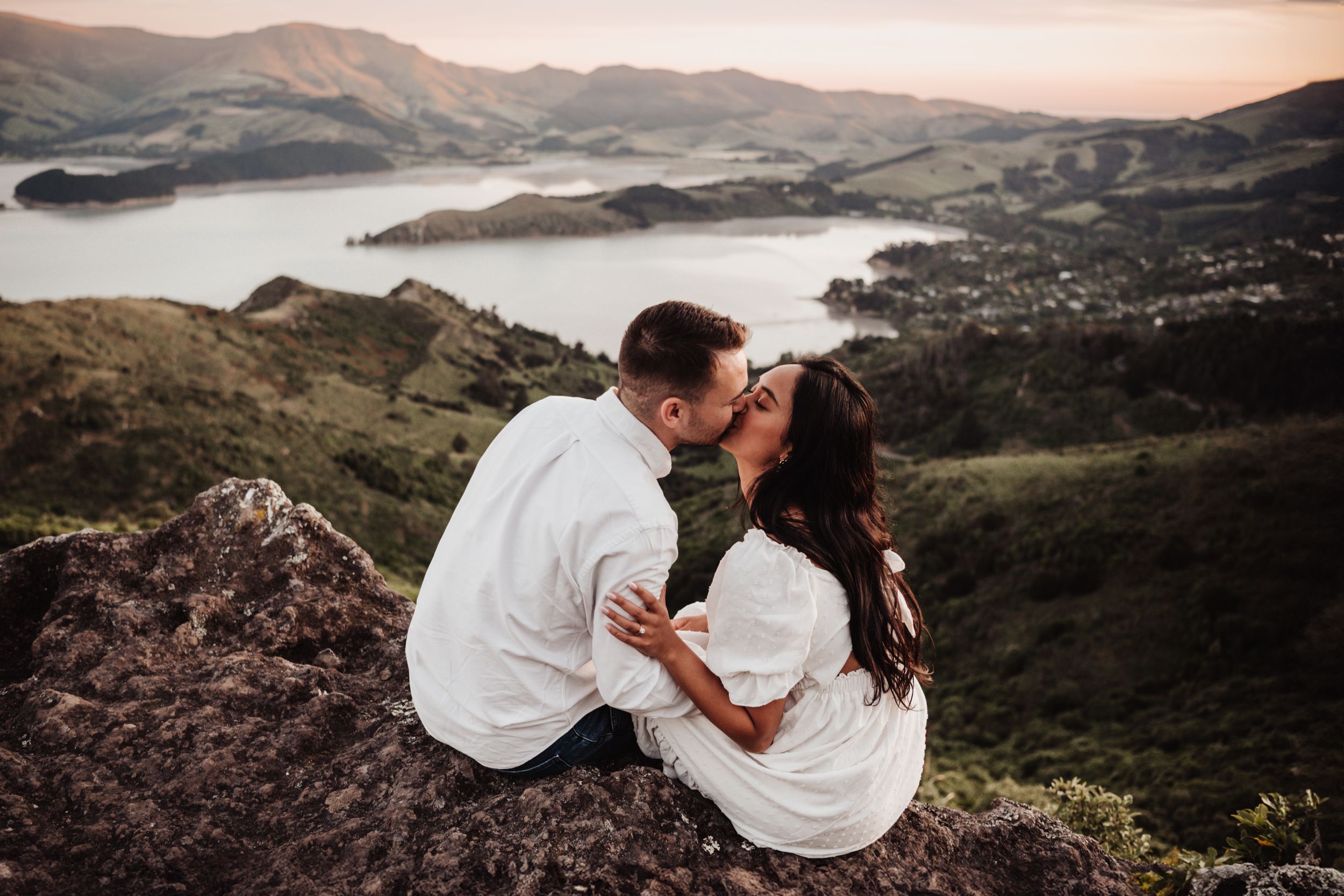 Two people share romantic moment overlooking scenic mountain lake vista.