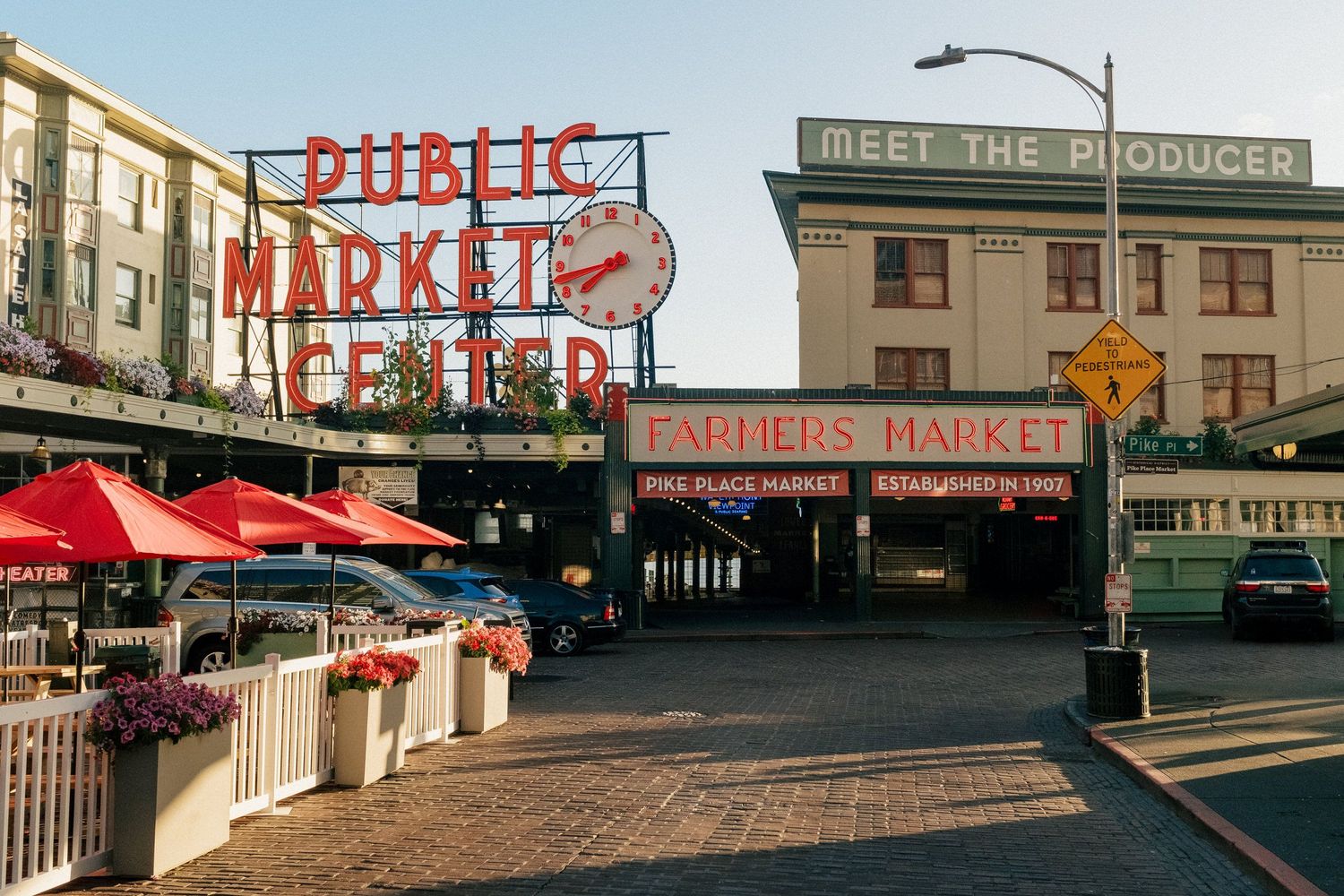 Iconic Pike Place Market entrance sign and red awnings in downtown Seattle on a sunny day.