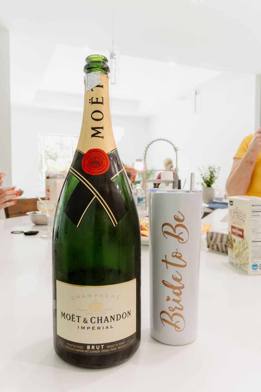 Large bottle of Moet & Chandon champagne next to a white and gold bride to be tumbler.