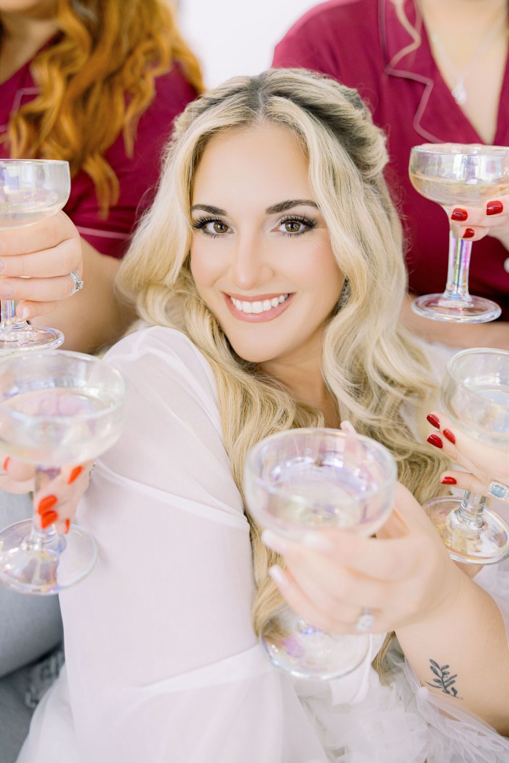 Wedding party member smiles while holding champagne glass in celebration.