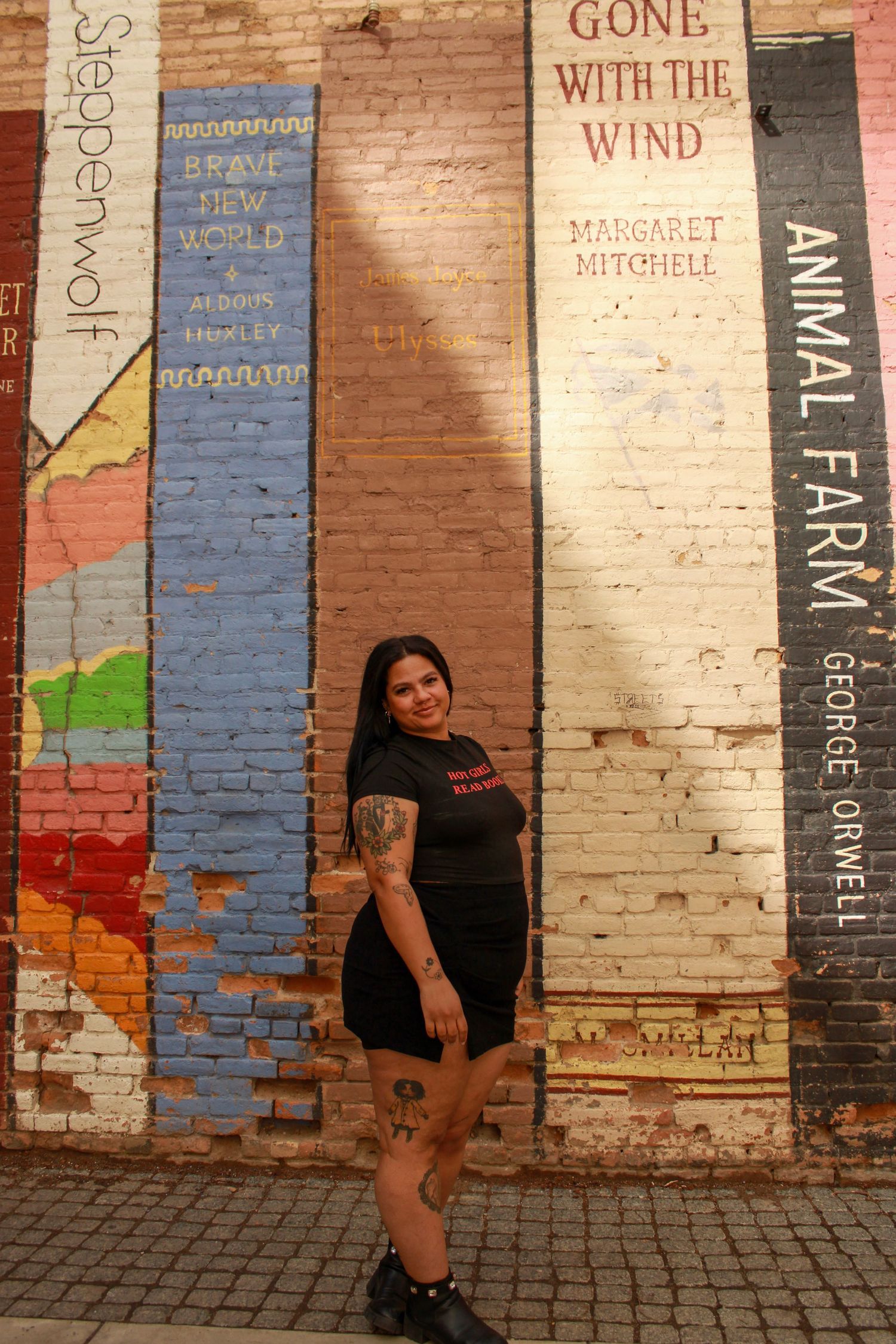Portrait in front of a wall painted with book titles including Gone with the Wind.