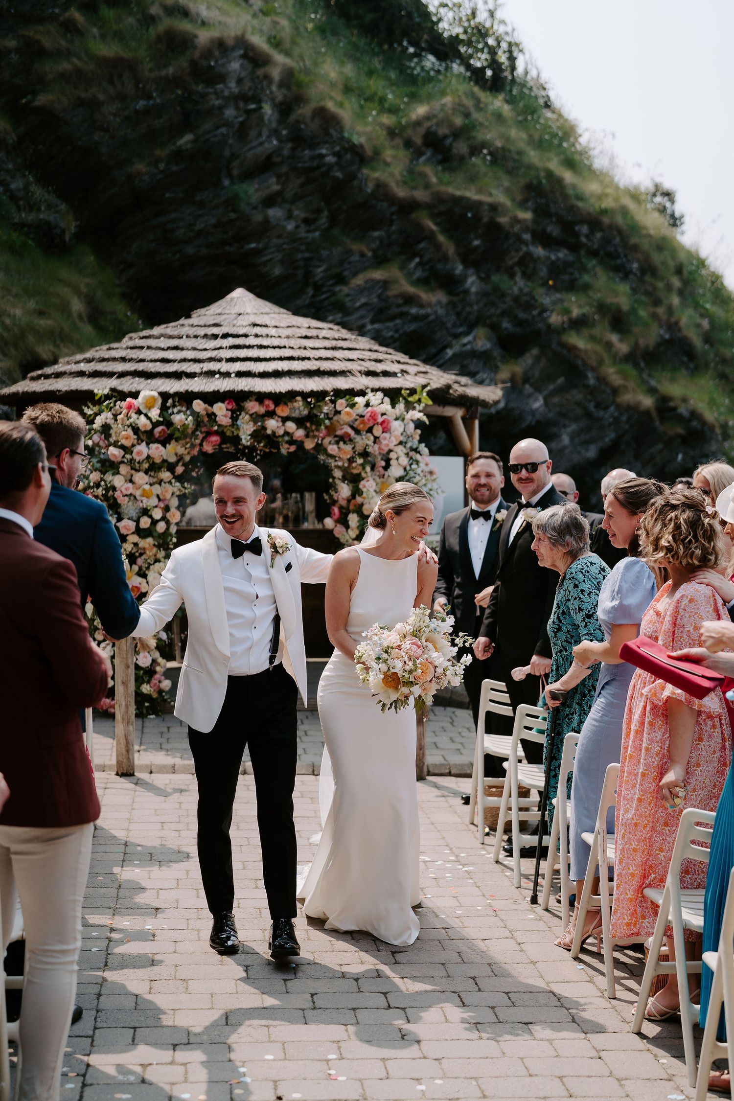 Bride and groom walking down aisle as husband and wife at tunnels beach wedding venue in north Devon