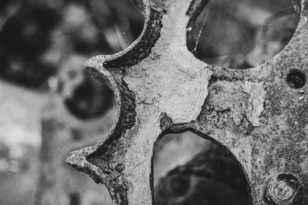 Abstract black and white close-up of circular holes or patterns in metal.