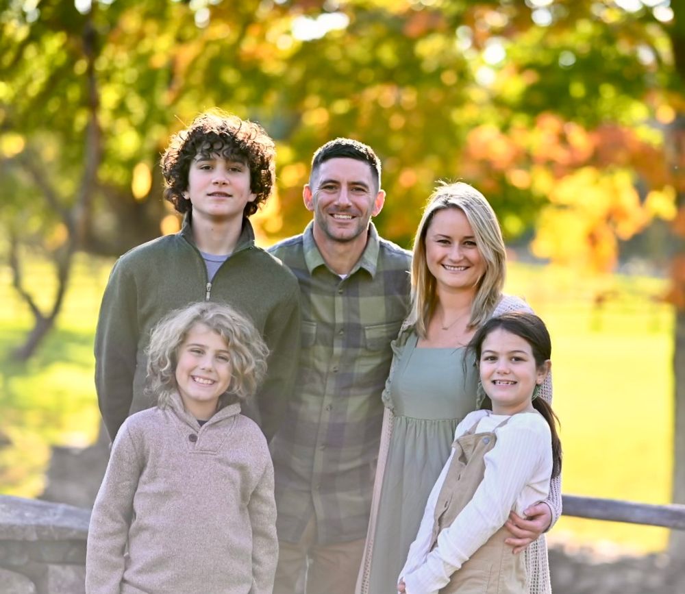Family photo session in a park during golden hour with autumn colors.
