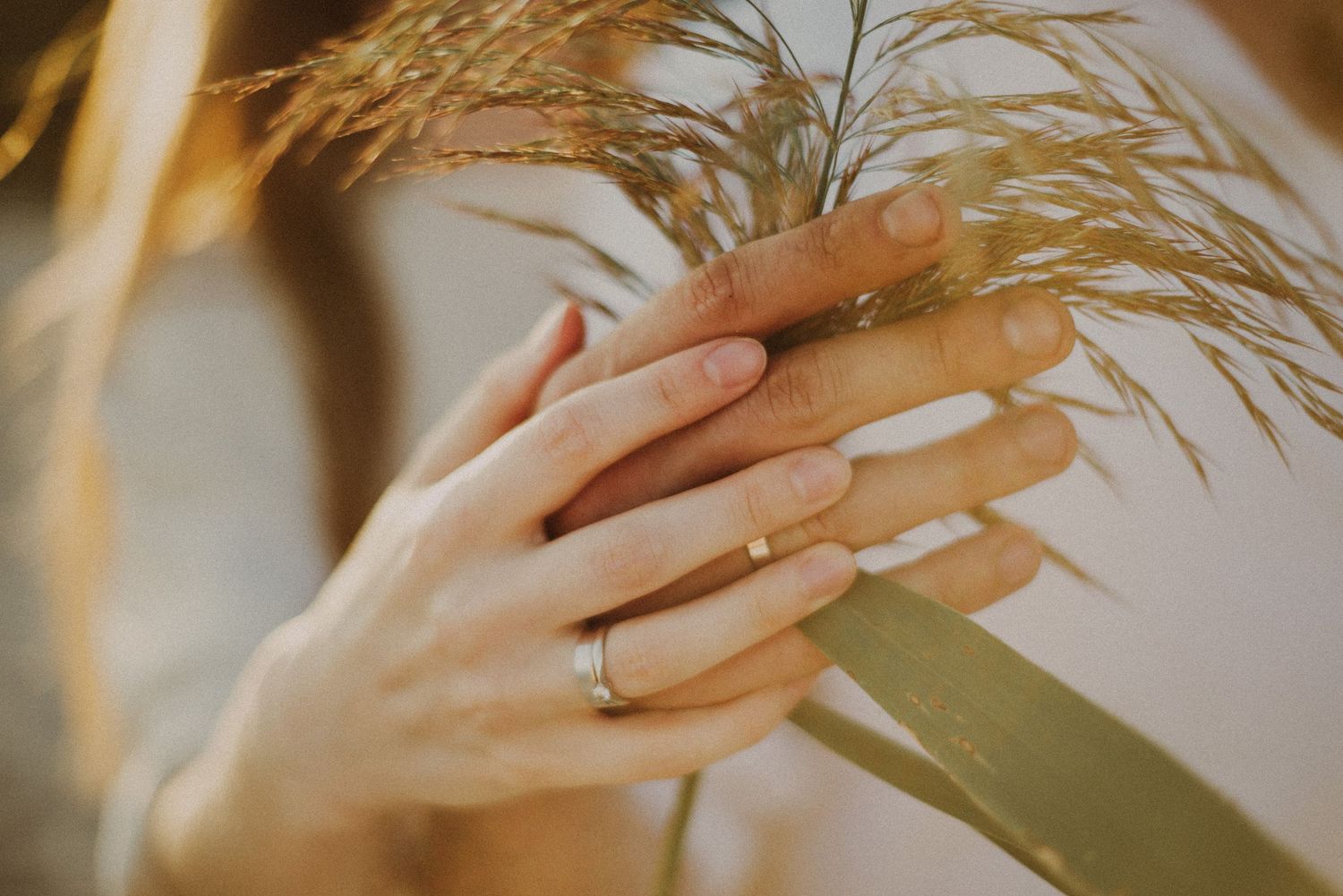 Close-up of engaged hands with wedding ring, natural couple photography in the fields near Amsterdam.