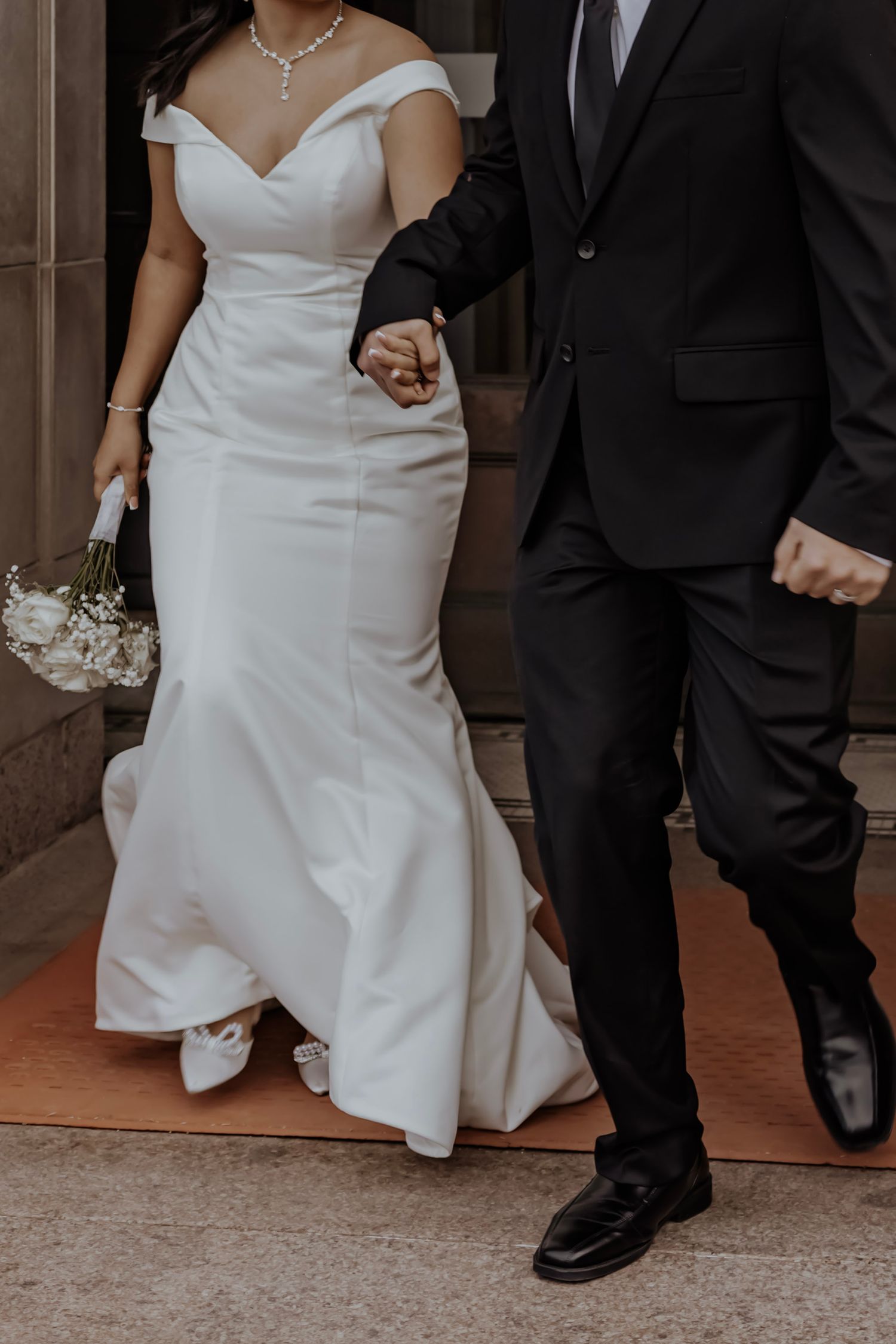 Bride and groom holding hands walking out of wedding ceremony
